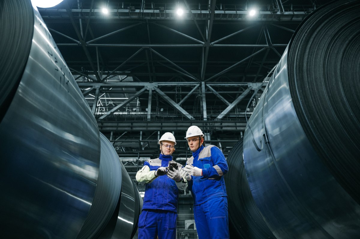 Industrial inspectors checking steel coils in a manufacturing plant